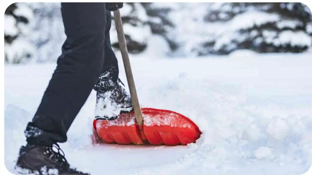 a person shoveling snow with a red shovel