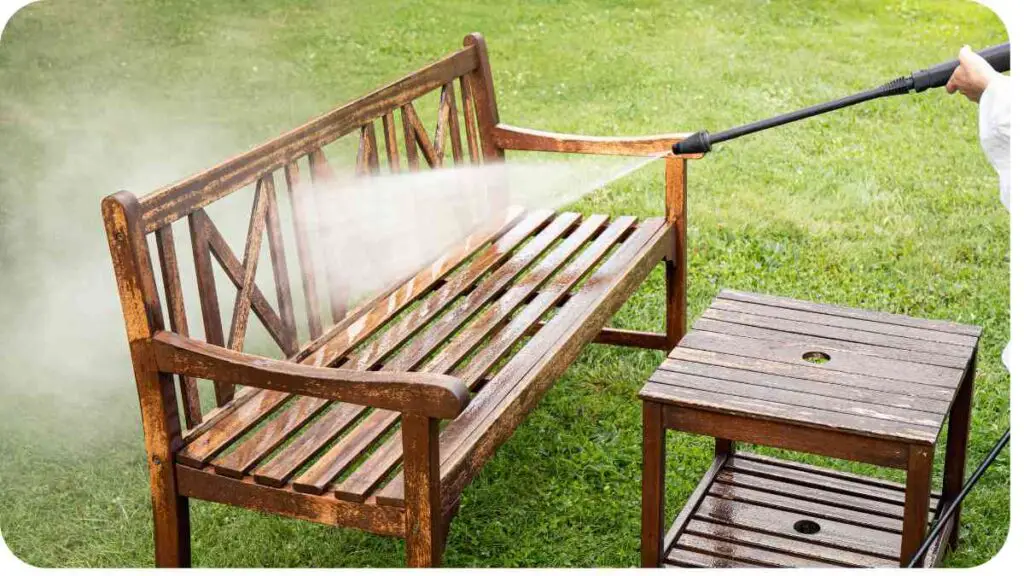 a person using a pressure washer to clean a wooden bench