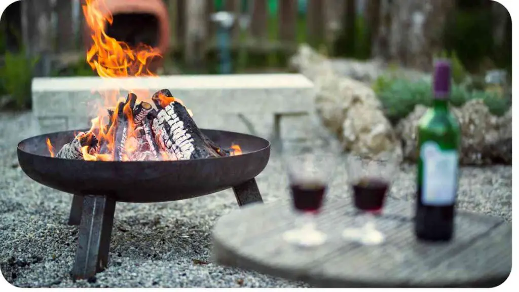 a fire pit with two wine glasses and a bottle of wine