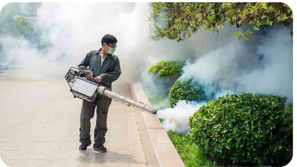 a person with a face mask spraying a bush with smoke