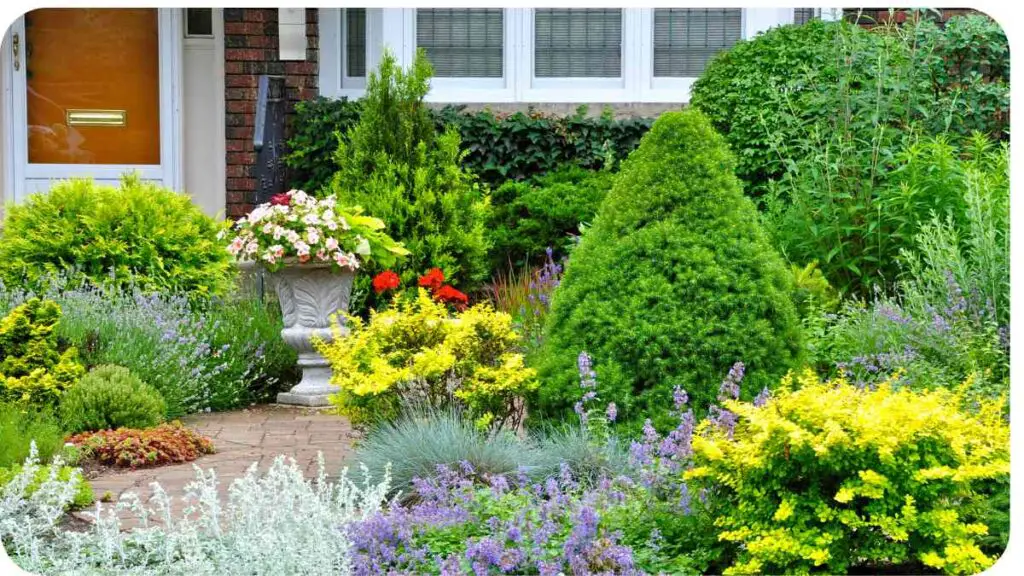 a garden with many different types of plants in front of a house