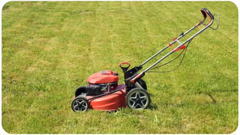 a red lawn mower sitting in the grass