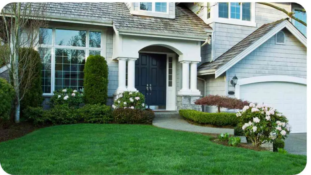 a house with a lawn and shrubs in front of it